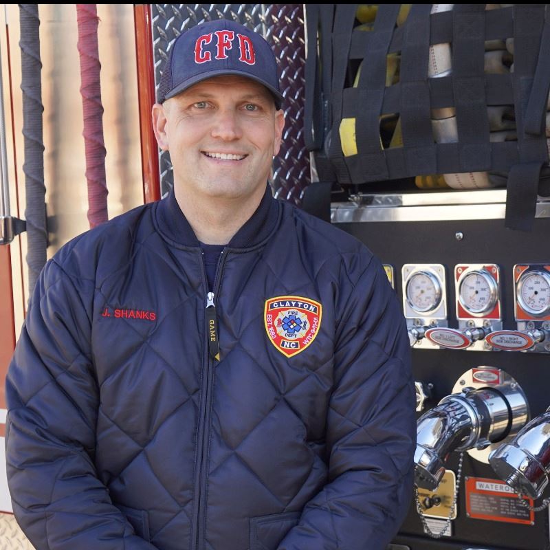 Joel Shanks Stands in Front of Clayton Fire Truck