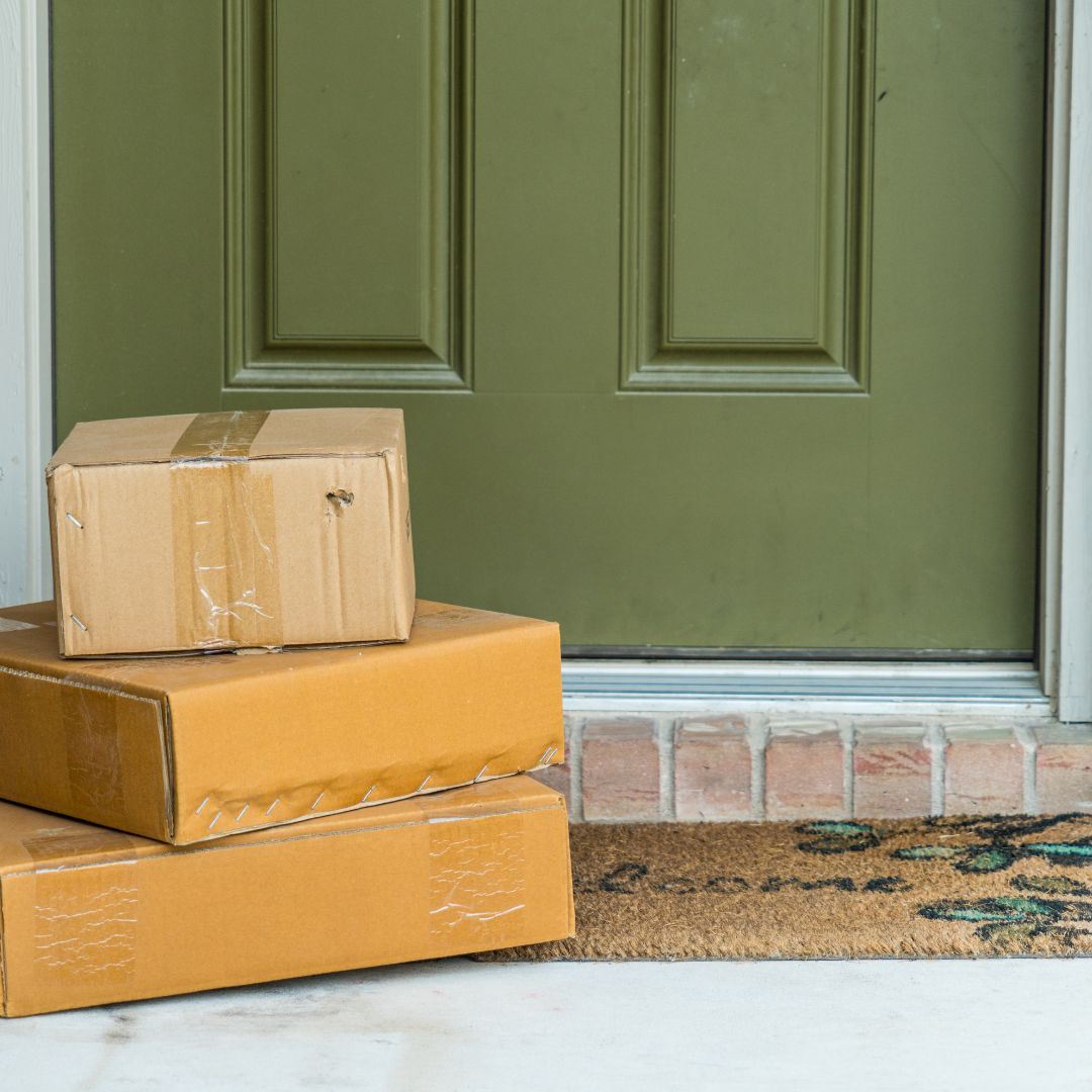Three Packages Sitting on Mat outside Front Door