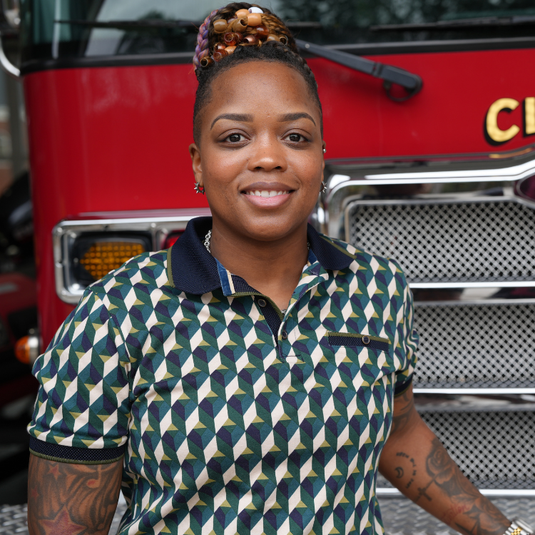 Earlece Hayes stands in front of a Clayton Fire Department Firetruck