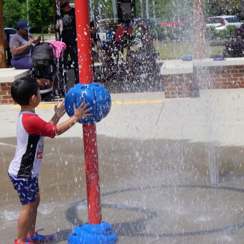Young boy plays in water at splash pad