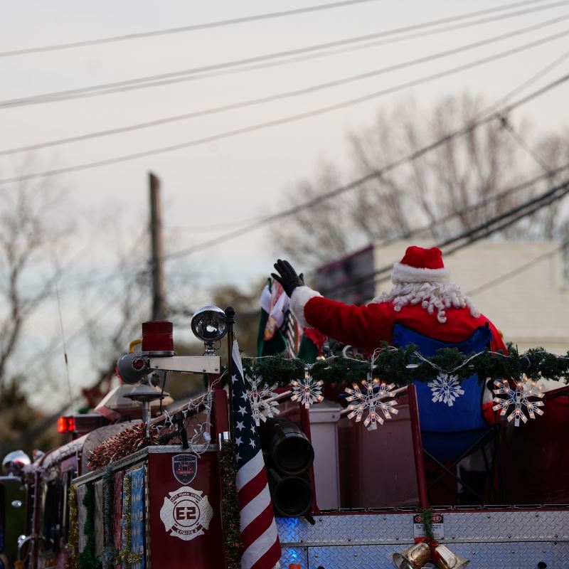 Santa Rides Fire Truck, waving in a parade