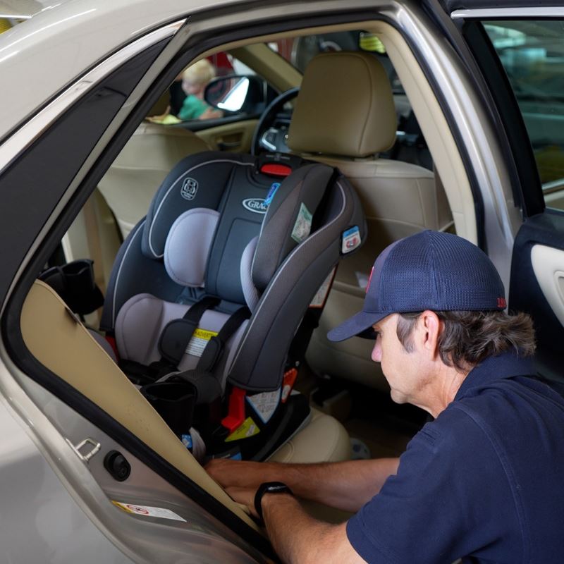 Clayton Fire community risk reduction specialist installs safety seat in car