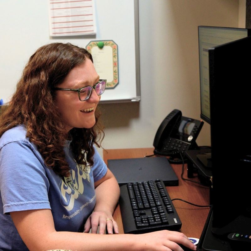 Fellow Laney Taylor works on computer at desk