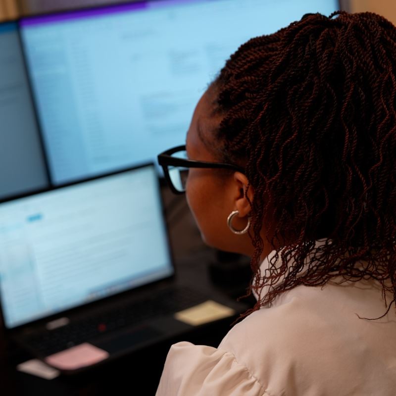 Development Services Manager Alicia Thomas sits at desk and works on computer